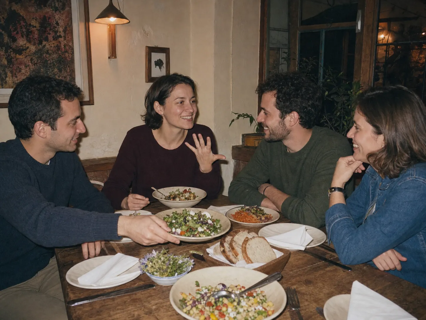 Freunde reichen beim Abendessen ein gemeinsames Gericht über den Tisch