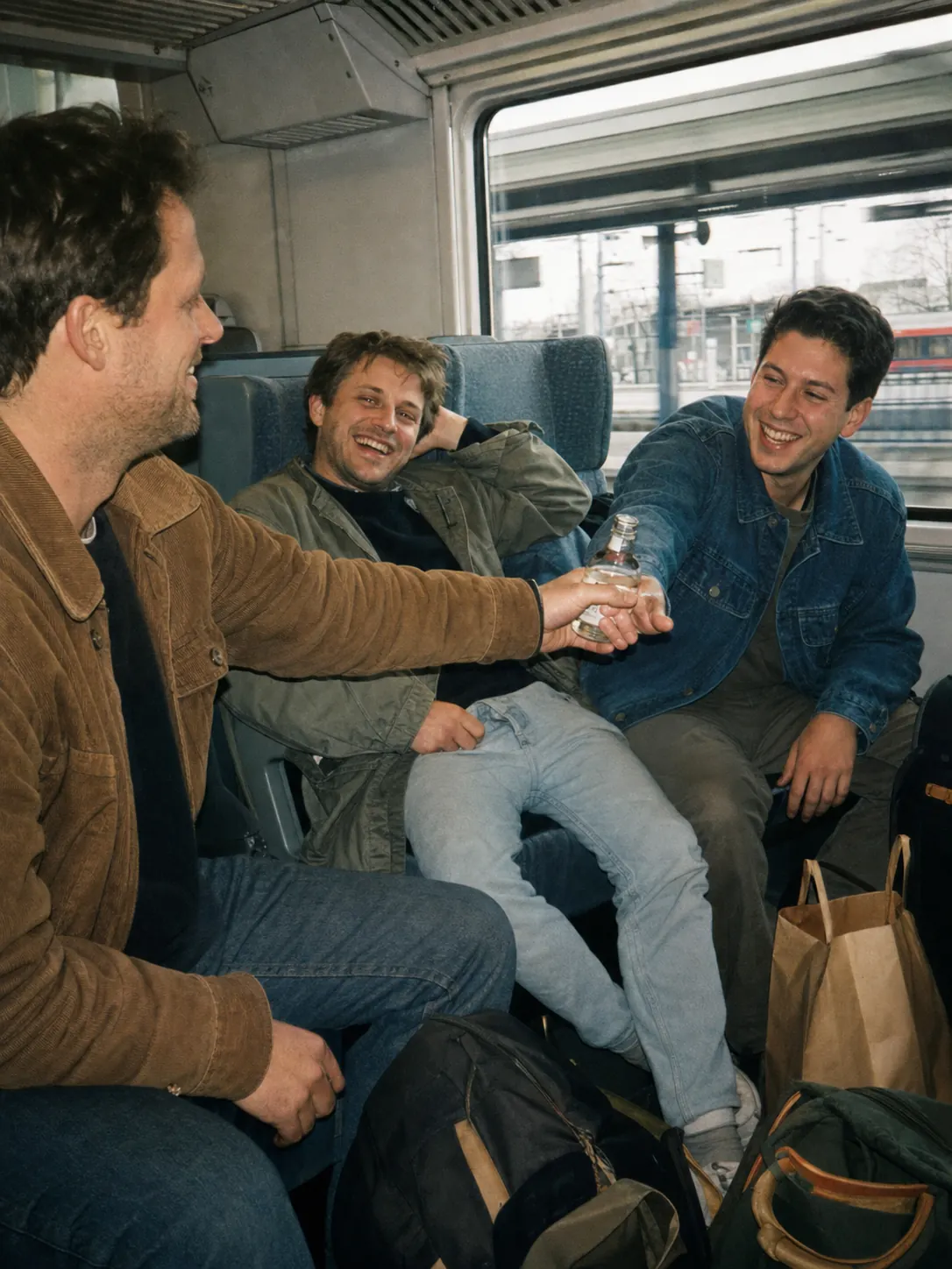 Freunde lachen auf der gemeinsamen Zugfahrt
